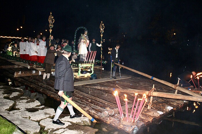 Auf einem der beiden Flöße stand eine Statue des heiligen Johannes Nepomuk. Foto: Peter Herrmann Johanni-Floßprozession auf der Loisach mit Statue des heiligen Johannes Nepomuk in Wolfratshausen