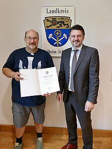Thomas Leinauer erhält von Landrat Dr. Johann Bertl die Ernennungsurkunde zum Naturschutzwächter.