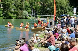 Zuschauerinnen und Zuschauer verfolgen die Sautrogregatta am Loisachufer in Wolfratshausen.