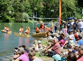 Zuschauerinnen und Zuschauer verfolgen die Sautrogregatta am Loisachufer in Wolfratshausen.