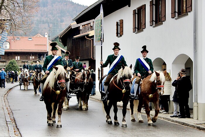 Reiter in grünen Trachten mit Federhüten auf geschmückten Pferden bei der Leonhardifahrt in Benediktbeuern.