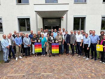 UV-Index-Tafeln für Landkreis-Gemeinden Gruppenfoto vor dem Landratsamt Weilheim-Schongau mit Landrat Johann Bertl, Vertreterinnen und Vertretern der Landkreis-Gemeinden sowie UV-Index-Tafeln.