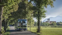 MVV-Regionalbus auf einer von Bäumen gesäumten Straße im Landkreis Bad Tölz-Wolfratshausen