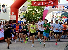 Alpenland Firmenlauf 2026 Start Laufstrecke Läufer starten beim Alpenland Firmenlauf 2026 in Geretsried unter dem Startbogen